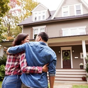 Couple walking up the steps of their home during the day.